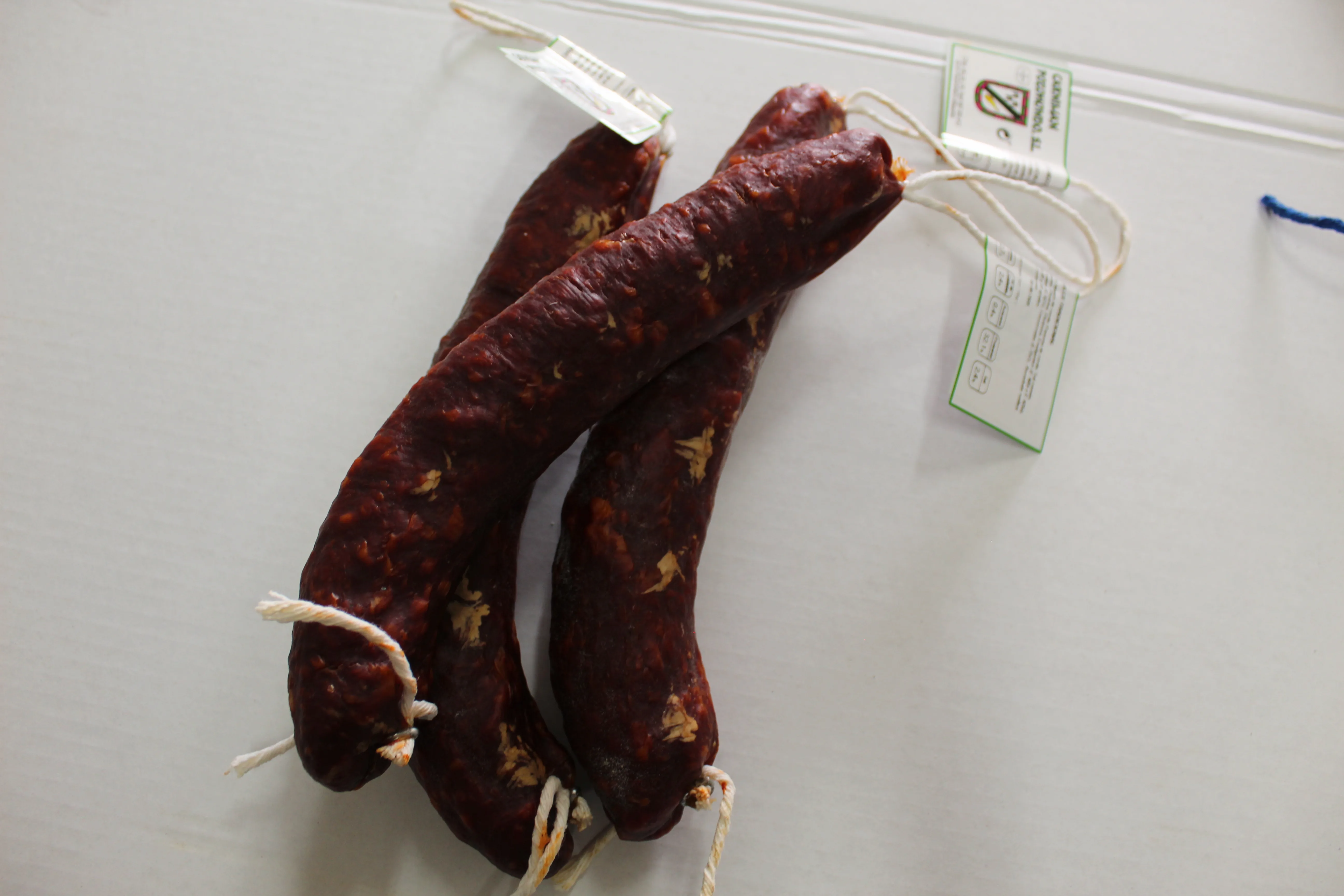 Chorizo curado oscuro artesano Cárnicas Pozo Hondo con etiqueta identificativa