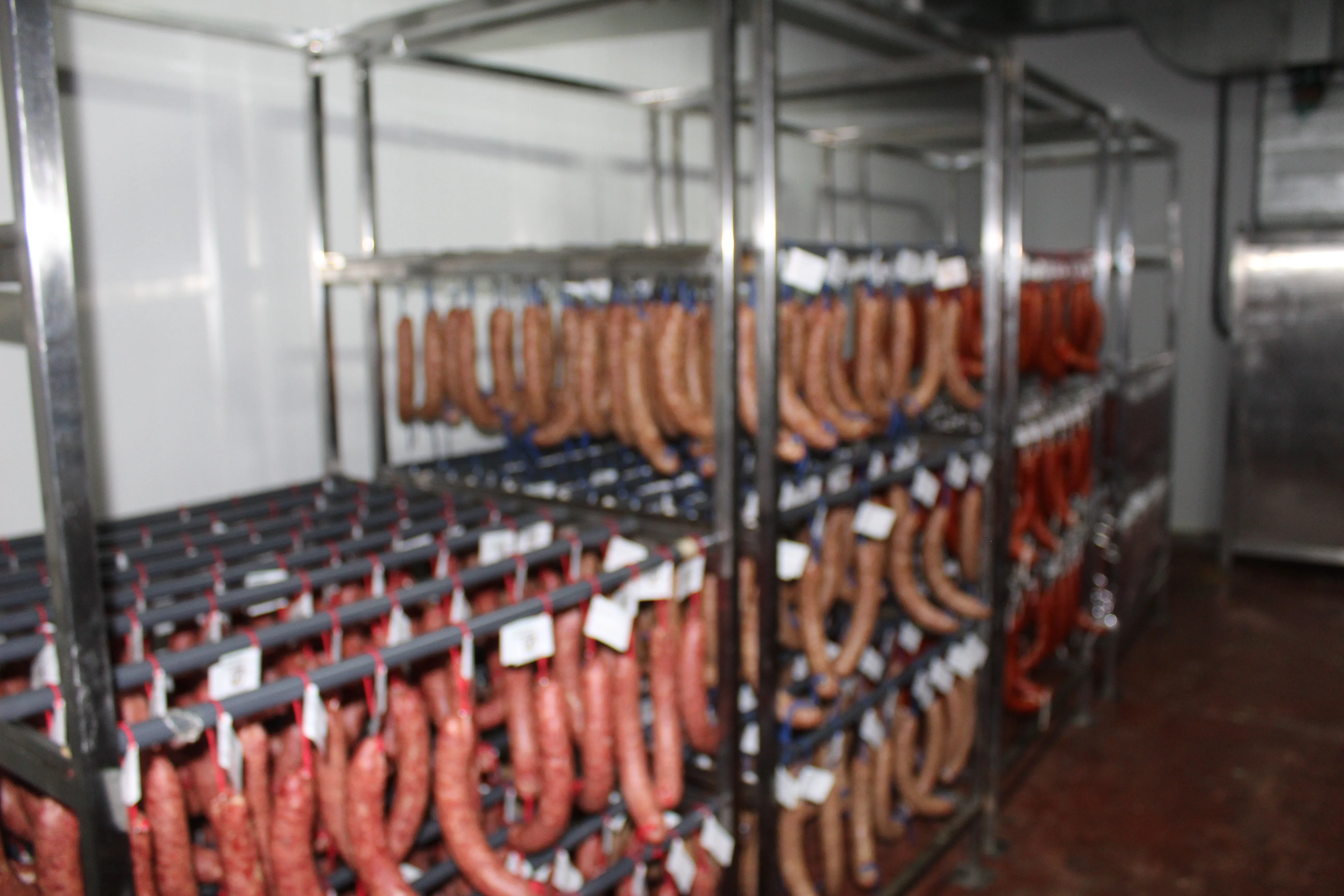 Sala de curación y producción de embutidos con estanterías en la fábrica Cárnicas Pozo Hondo